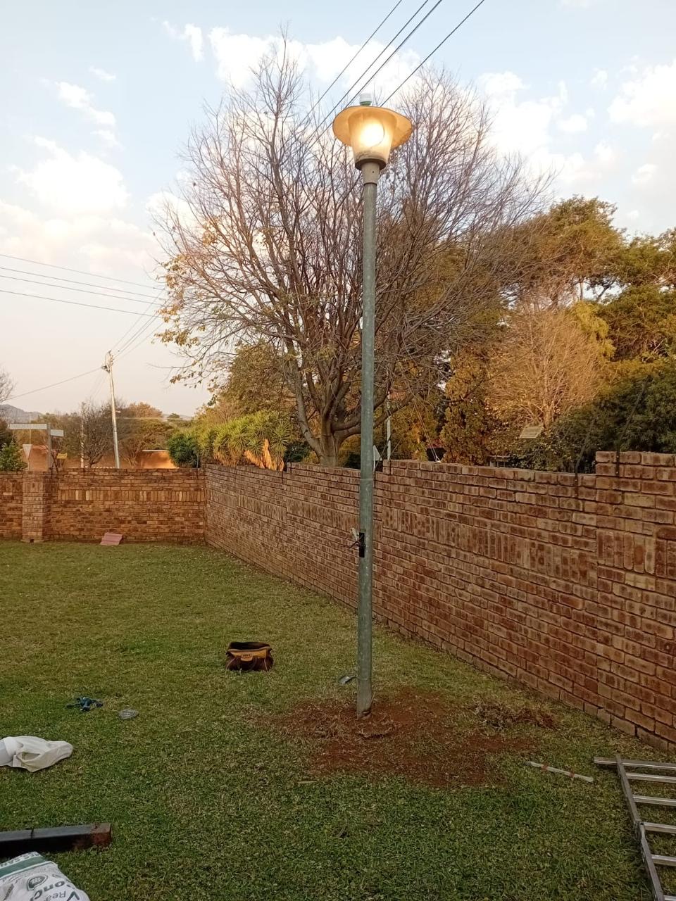 Newly installed garden lamp pole lighting up a Gauteng property boundary wall at dusk